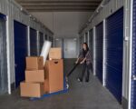 Woman rolling carton boxes into storage