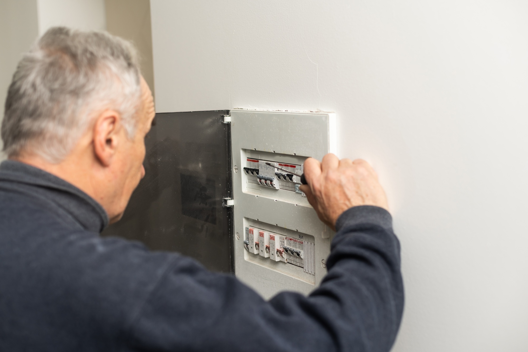 Elder man fixing an electric meter