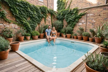 Piscine hors sol installée dans un petit jardin urbain avec terrasse en bois et plantes en pots